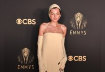 Emma Corrin mit Haube und Krallen auf dem roten Teppich der Emmy Awards.