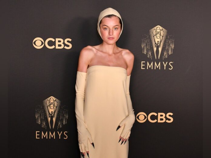 Emma Corrin mit Haube und Krallen auf dem roten Teppich der Emmy Awards.
