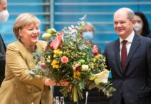 Angela Merkel freut sich über die Abschiedsblumen von Olaf Scholz.