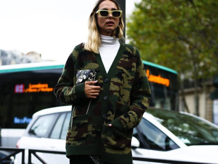 Mode-Influencerin Candela Pelizza kombiniert ihren Camouflage-Cardigan mit Lederbleistiftrock und weißem Rollkragenpullover.