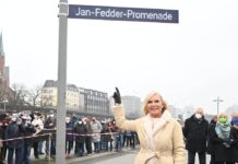 Witwe Marion Fedder unter dem neuen Straßenschild der Jan-Fedder-Promenade.