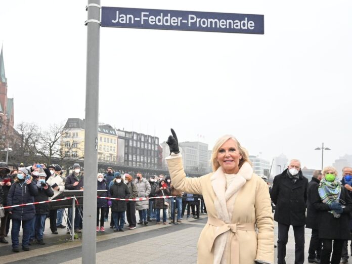 Witwe Marion Fedder unter dem neuen Straßenschild der Jan-Fedder-Promenade.