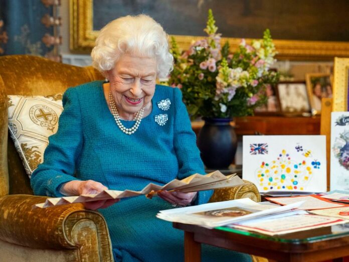Queen Elizabeth II. amüsiert sich über alte Glückwunschkarten.