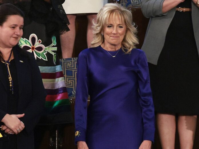 First Lady Jill Biden in einem blauen Kleid mit Sonnenblumenstickerei am Ärmel.
