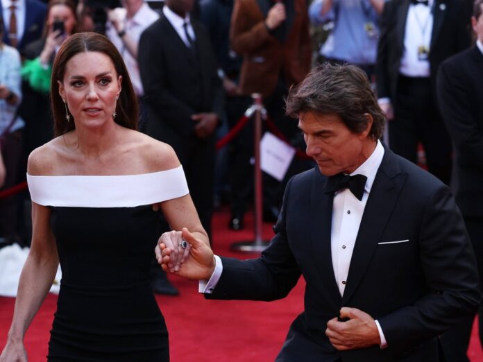 Tom Cruise hilft Herzogin Kate auf dem roten Teppich die Treppen hoch.