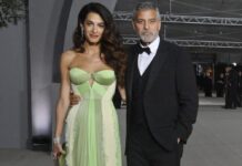 Amal Clooney in einem grünen Designerkleid und George Clooney im eleganten Dreiteiler.