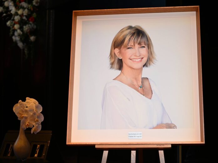 Ein Bild von Olivia Newton-John auf der Bühne während einer staatlichen Gedenkveranstaltung in der Hamer Hall in Melbourne.