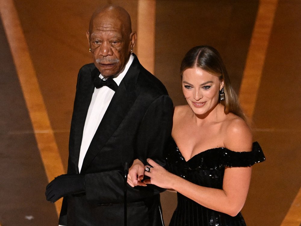 Morgan Freeman mit Margot Robbie und dem Handschuh auf der Oscarbühne.