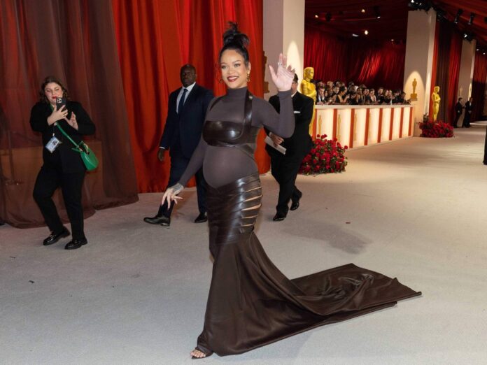Rihanna zeigt ihren Babybauch auf dem champagnerfarbenen Teppich bei den Academy Awards.
