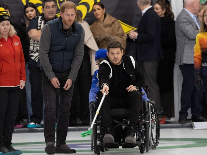 Voller Einsatz: Michael Bublé probierte neben Prinz Harry Rollstuhl-Curling aus. Im Hintergrund schaute Meghan zu.